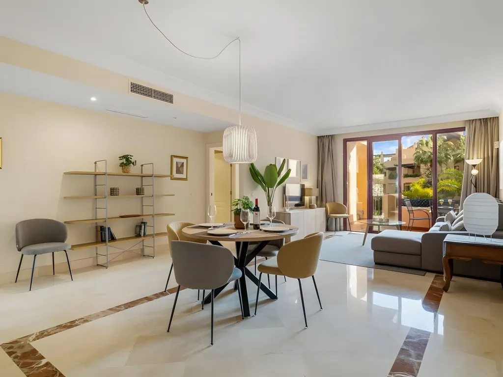 Apartamento Bahía Alcántara Salón comedor moderno con mesa redonda y acceso a terraza exterior
