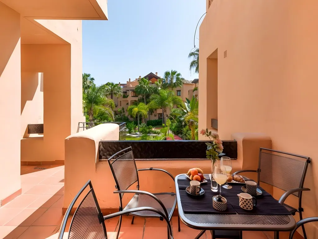Apartamento Bahía Alcántara Terraza con mesa y vistas a jardín tropical resort
