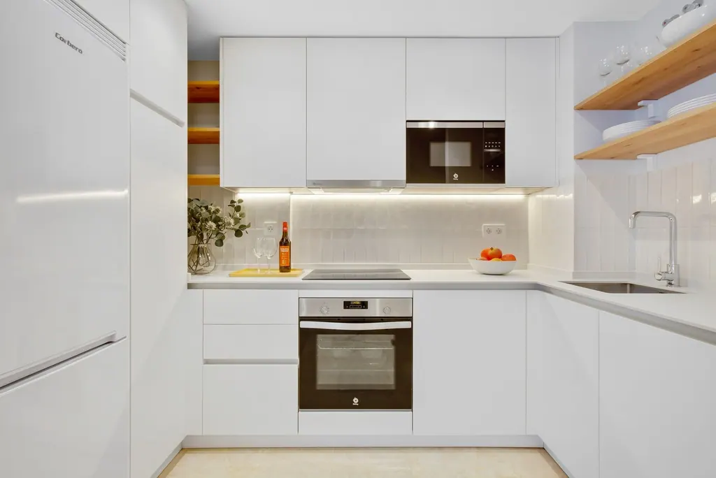 Castillo de Santa Clara Cocina moderna blanca con electrodomésticos empotrados e iluminación LED bajo muebles