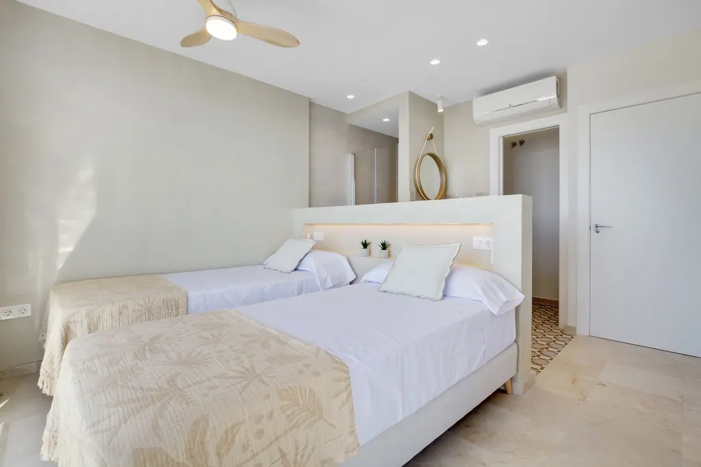 Castillo de Santa Clara Habitación moderna con dos camas individuales blancas y decoración minimalista beige