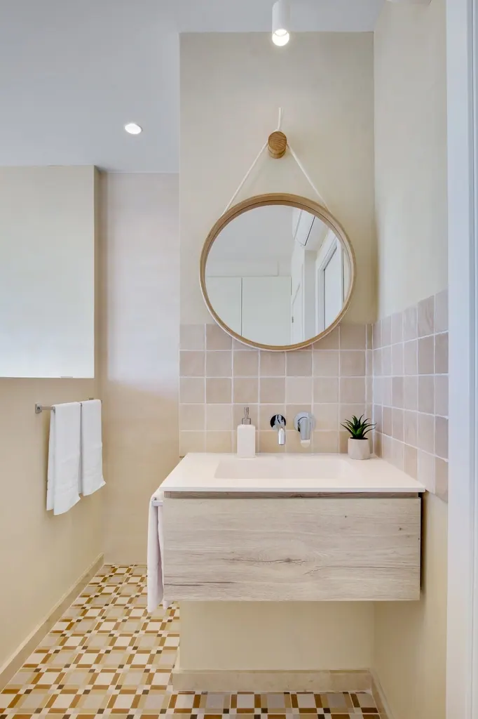 Castillo de Santa Clara Baño moderno minimalista con espejo redondo colgante y lavabo flotante de madera