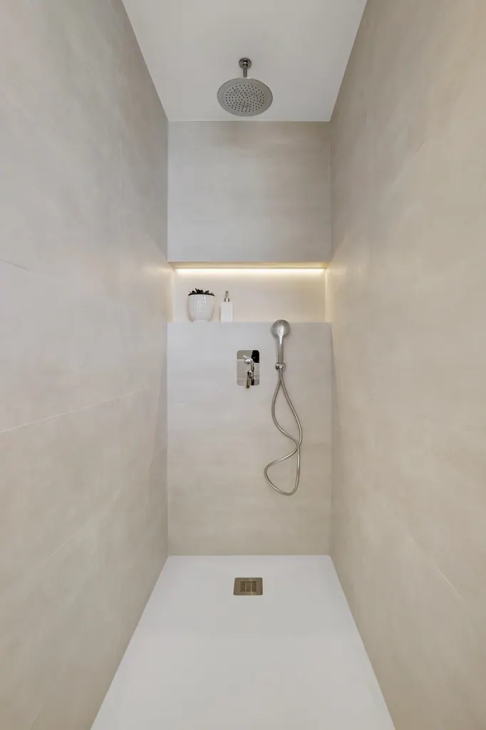 Castillo de Santa Clara Ducha moderna minimalista con iluminación LED y acabados en tonos neutros