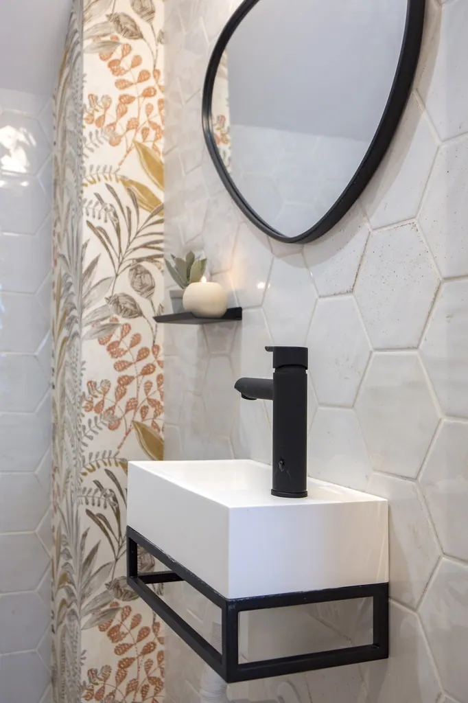 Casa Vacacional Baño moderno con lavabo blanco grifo negro y espejo redondo