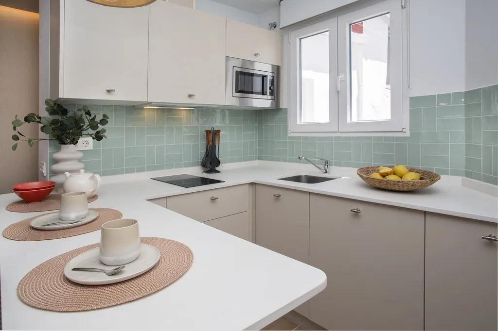 Casa Vacacional Cocina moderna con azulejos verdes menta y encimera blanca minimalista