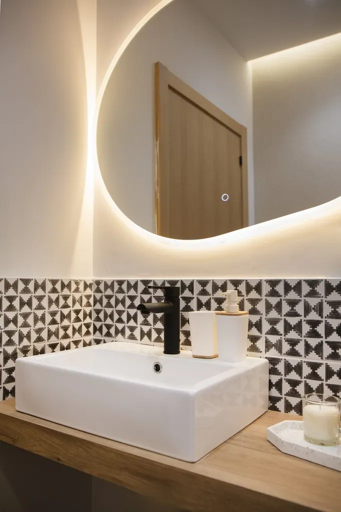 Casa Vacacional Baño moderno con espejo redondo iluminado y lavabo rectangular blanco