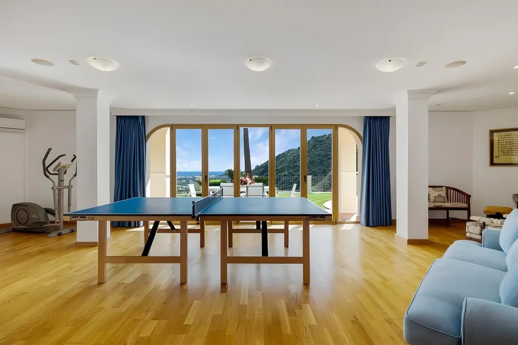 Villa los Arqueros Golf Sala de juegos moderna con mesa de ping pong y vistas a montaña verde