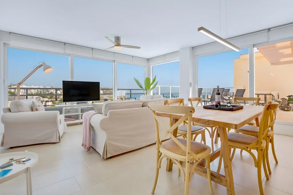 Ático en la Carihuela Salón comedor moderno con vistas al mar y decoración minimalista blanca