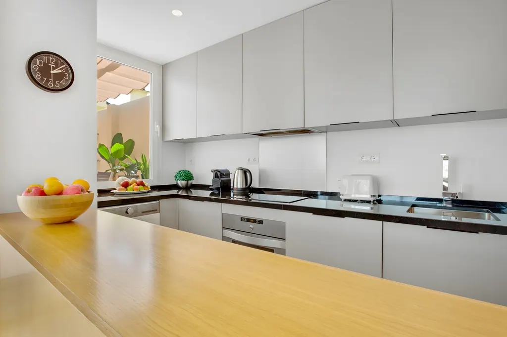 Ático en la Carihuela Cocina moderna minimalista con encimera negra y muebles grises claros