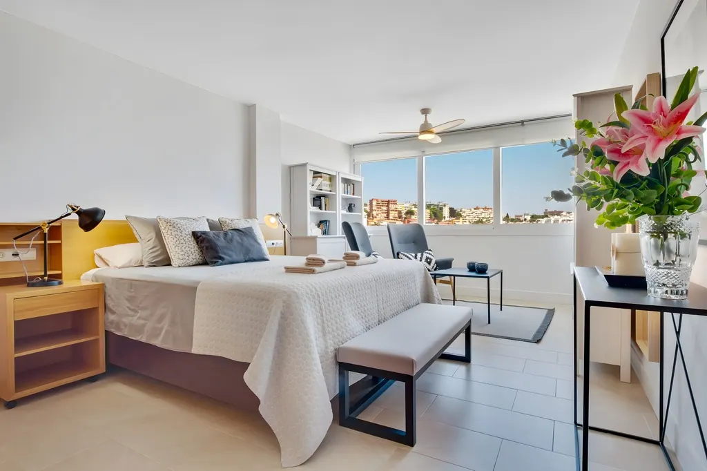 Ático en la Carihuela Dormitorio moderno luminoso con ventanas grandes y decoración minimalista contemporánea