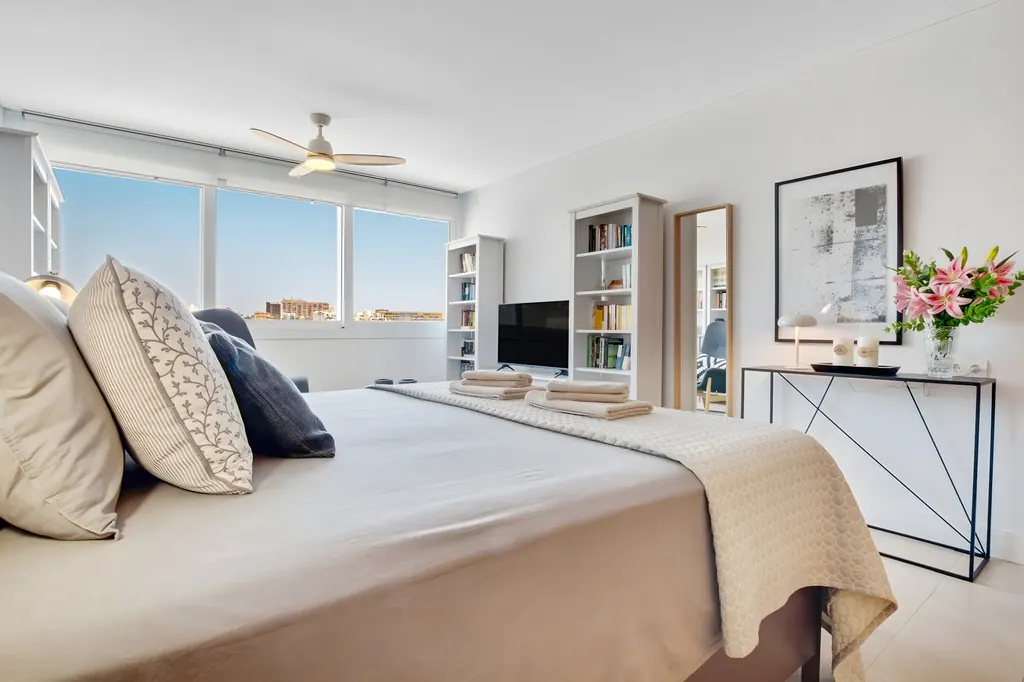 Ático en la Carihuela Dormitorio moderno luminoso con cama doble y ventanas grandes