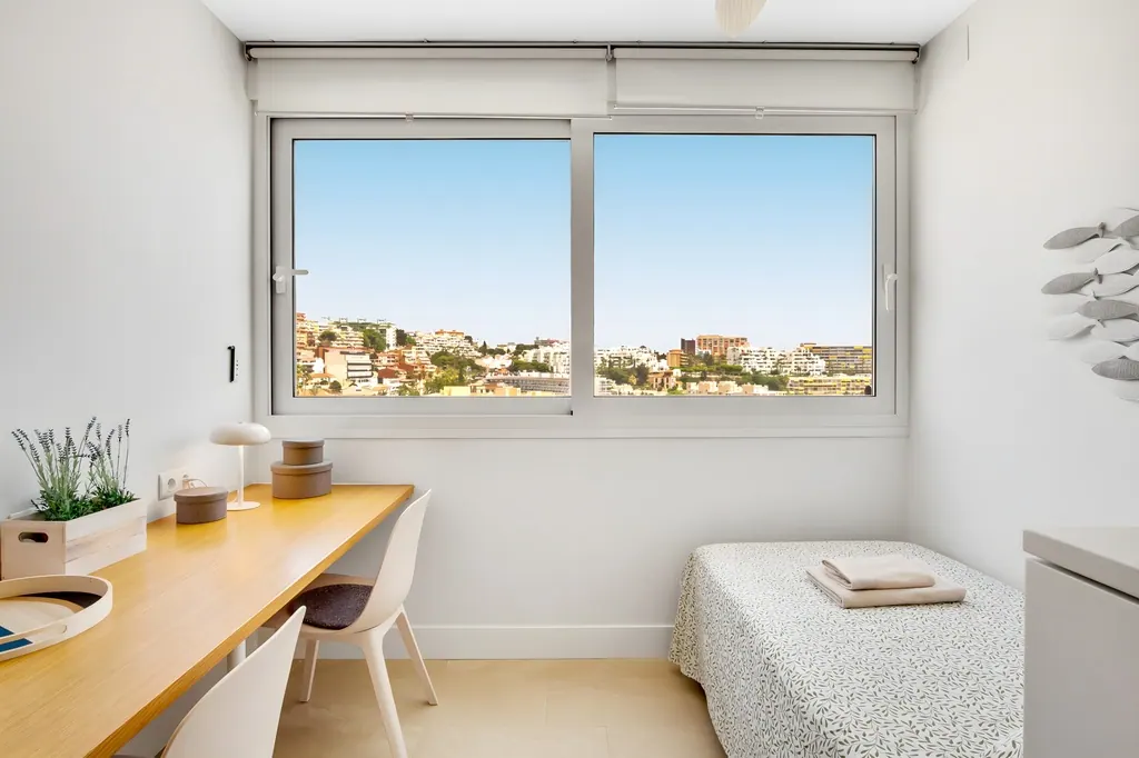 Ático en la Carihuela Habitación minimalista con escritorio de madera y ventana con vistas urbanas