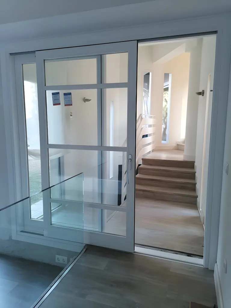 Chalet Unifamiliar Puerta corredera de vidrio con marco gris en interior moderno minimalista