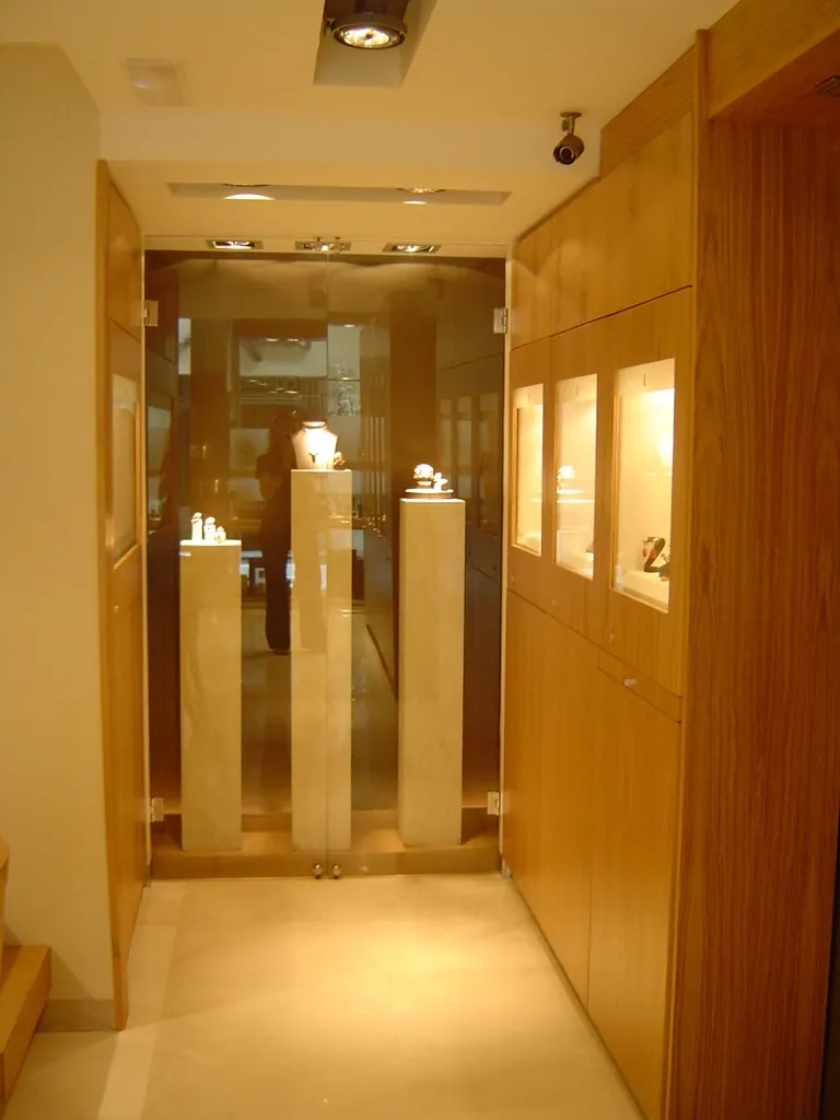 Comerciales Entrada moderna de tienda joyería con vitrinas iluminadas y puertas de vidrio