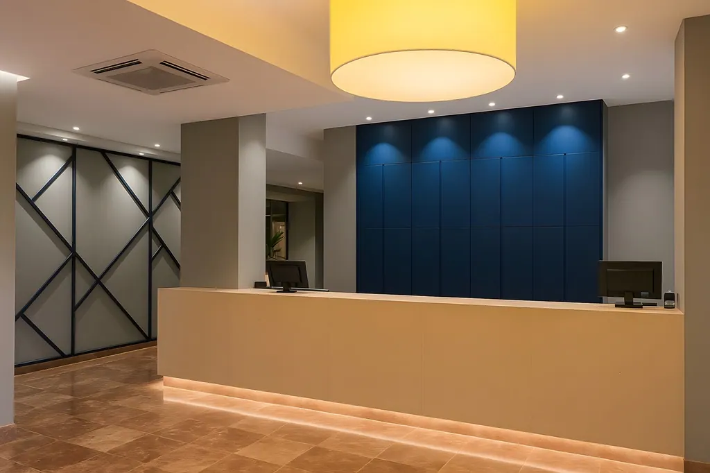 Comerciales Recepción moderna de hotel con mostrador iluminado y pared azul