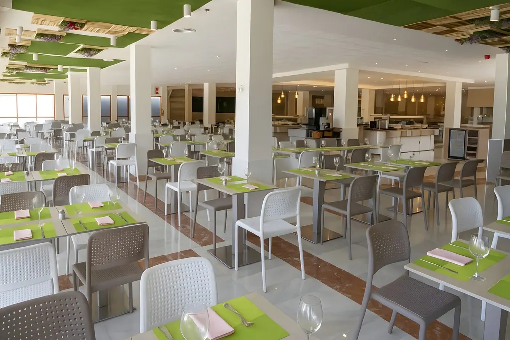 Comerciales Comedor moderno de hotel con mesas verdes y sillas blancas