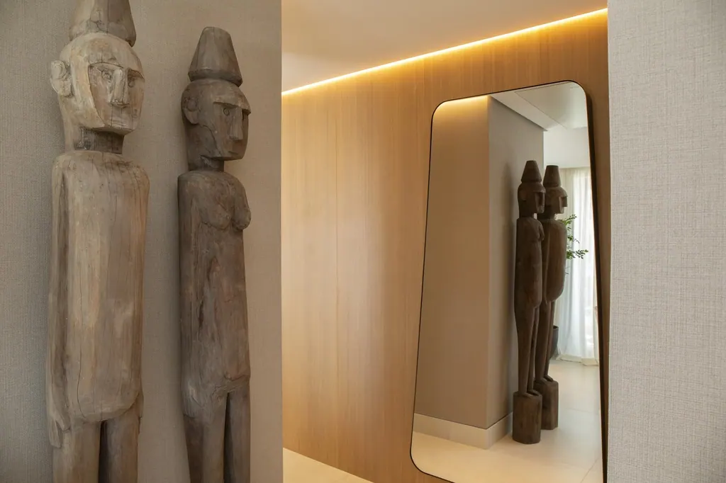 Málaga Towers Esculturas africanas de madera junto a espejo moderno con iluminación cálida