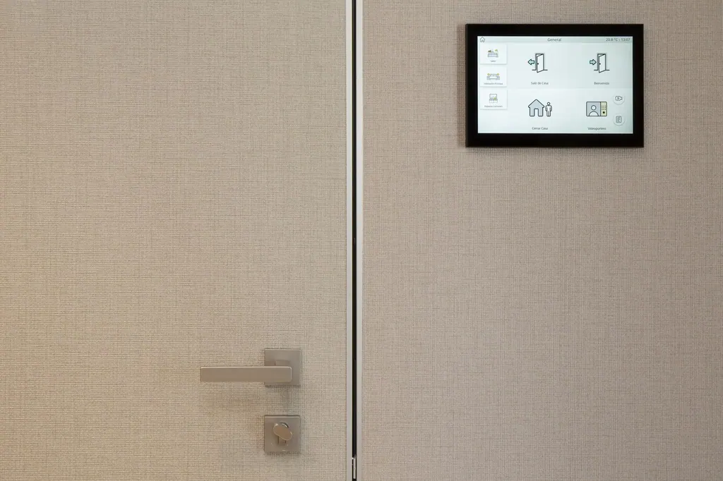 Málaga Towers Panel de control domótico digital instalado en pared junto a puerta moderna