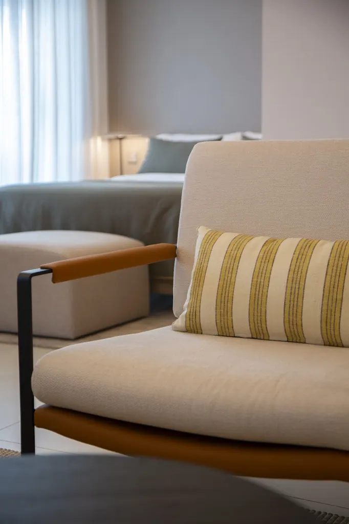 Málaga Towers Sillón beige moderno con cojín de rayas en sala luminosa