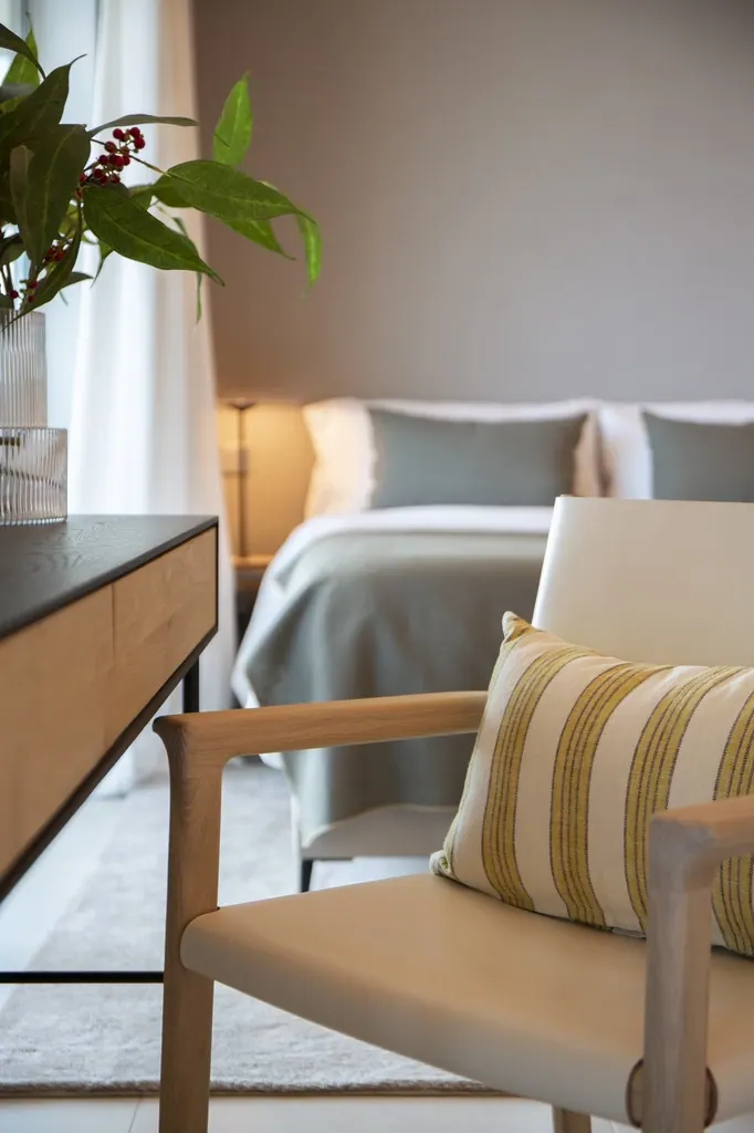 Málaga Towers Dormitorio moderno con sillón beige y decoración minimalista elegante
