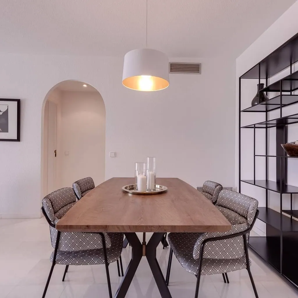 Las Gaviotas Comedor moderno con mesa de madera y sillas tapizadas bajo lámpara colgante