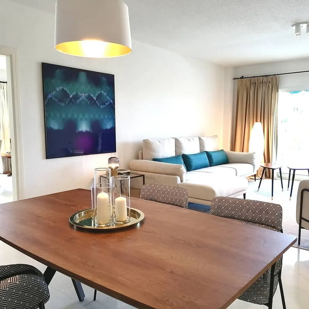 Las Gaviotas Sala de estar moderna con sofá blanco, mesa de madera y decoración minimalista