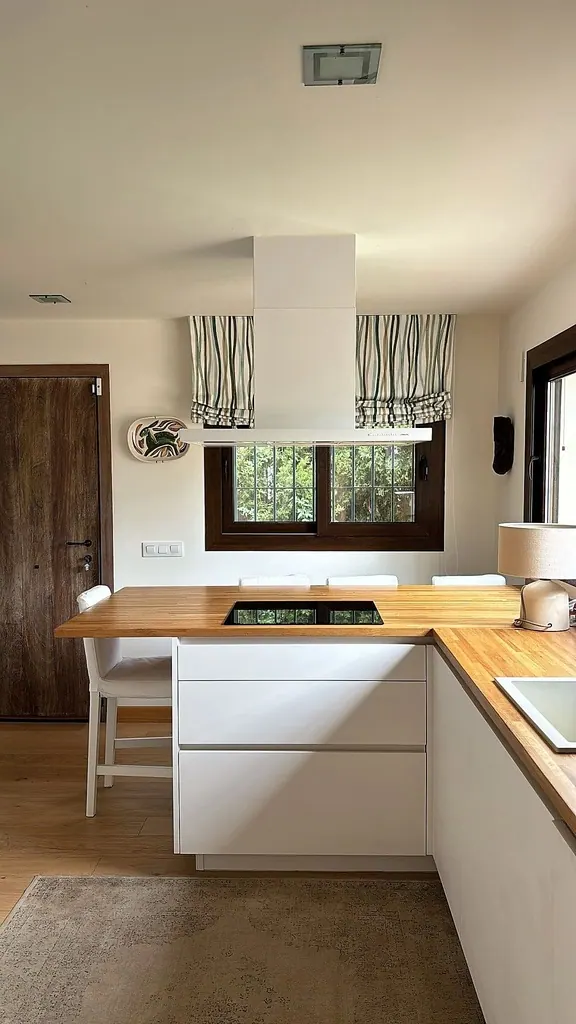 Villa el Olivar Cocina moderna con isla de madera y campana extractora blanca