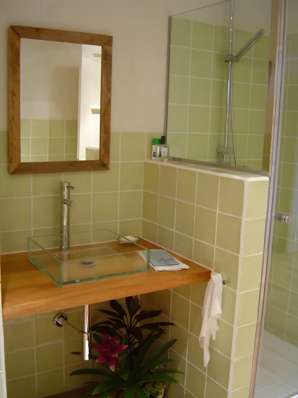 Villa el Olivar Baño moderno con lavabo de cristal, espejo de madera y azulejos verdes