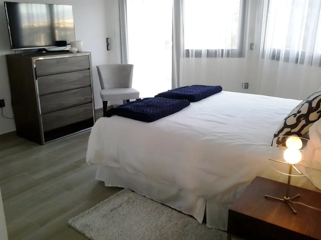 Villa Nueva Andalucía Dormitorio moderno minimalista con cama blanca y muebles grises contemporáneos